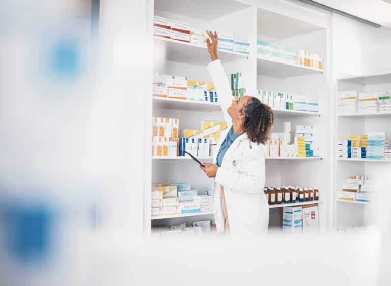 photo d'une pharmacienne faisant l'inventaire des rayons de médicaments